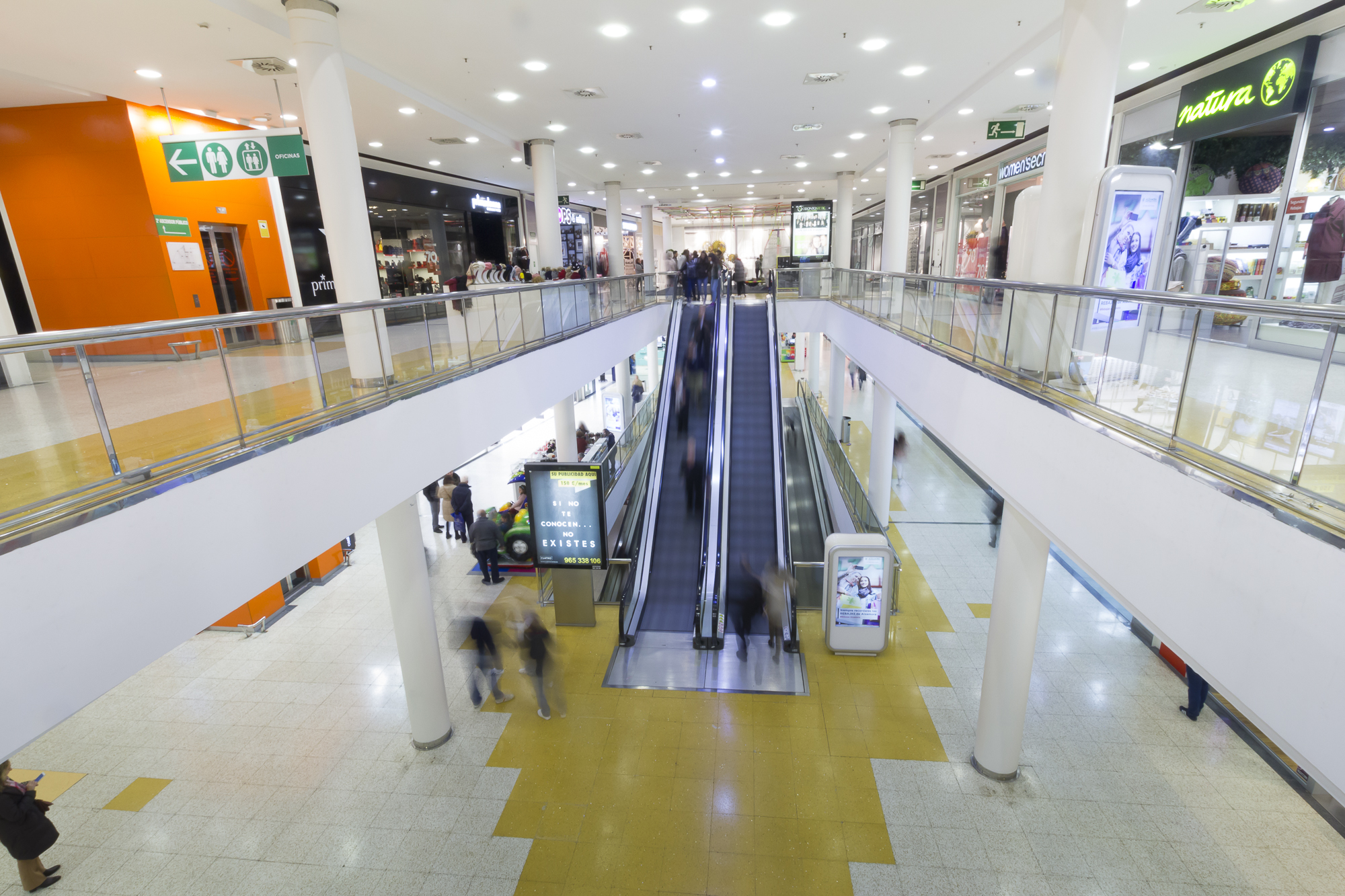 Imagen del centro comercial Alzamora Alcoy, escaleras mecánicas y t iendas para ilustrar los festivos de apertura en Alzamora.